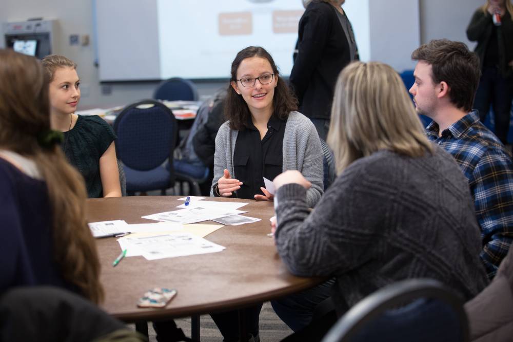 Attendees discuss a topic at a round table.